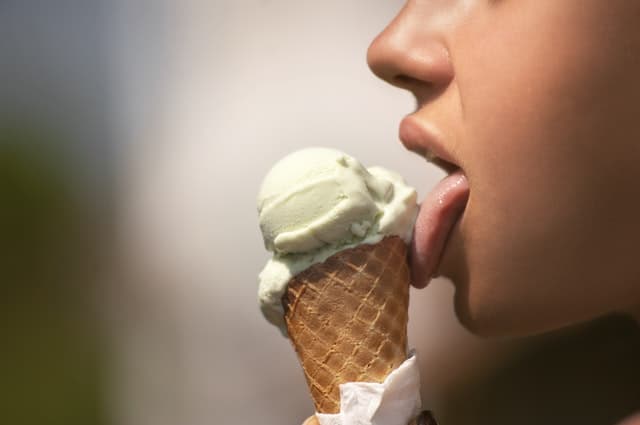 アイスクリームを舐める女性の横顔の画像
