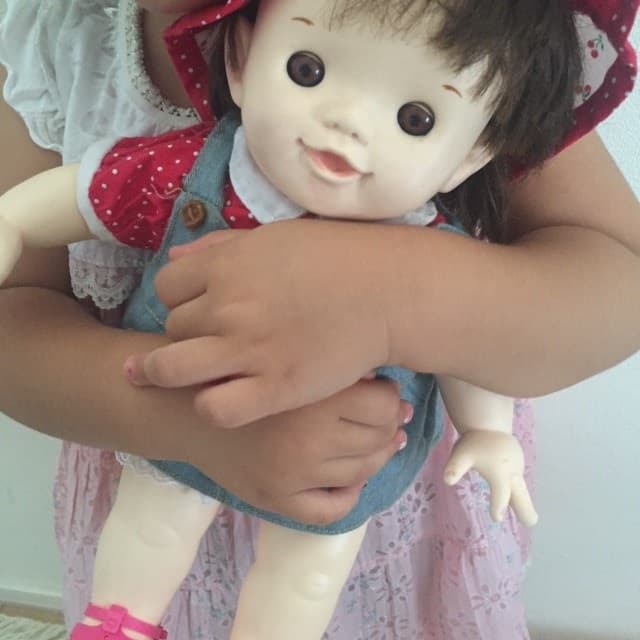 娘がぽーちゃん人形を抱えている写真