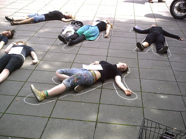 フラッシュモブで地面に横たわっている人々の画像