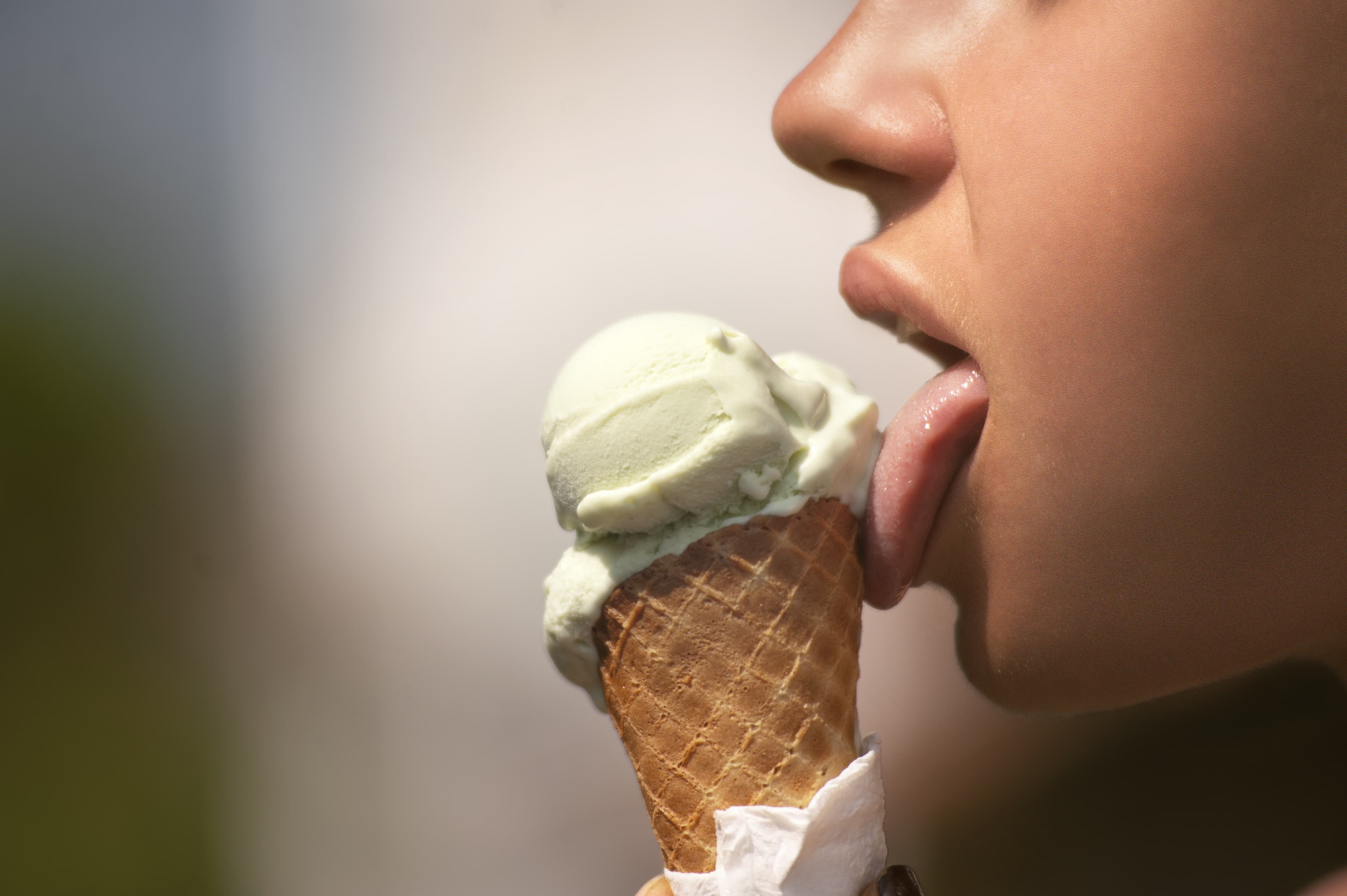 アイスクリームを舐める女性の口元画像