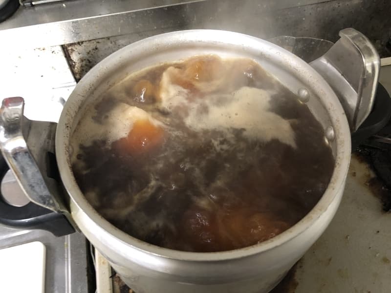 醤油と水と豚肩ロースが入った鍋が沸騰している画像